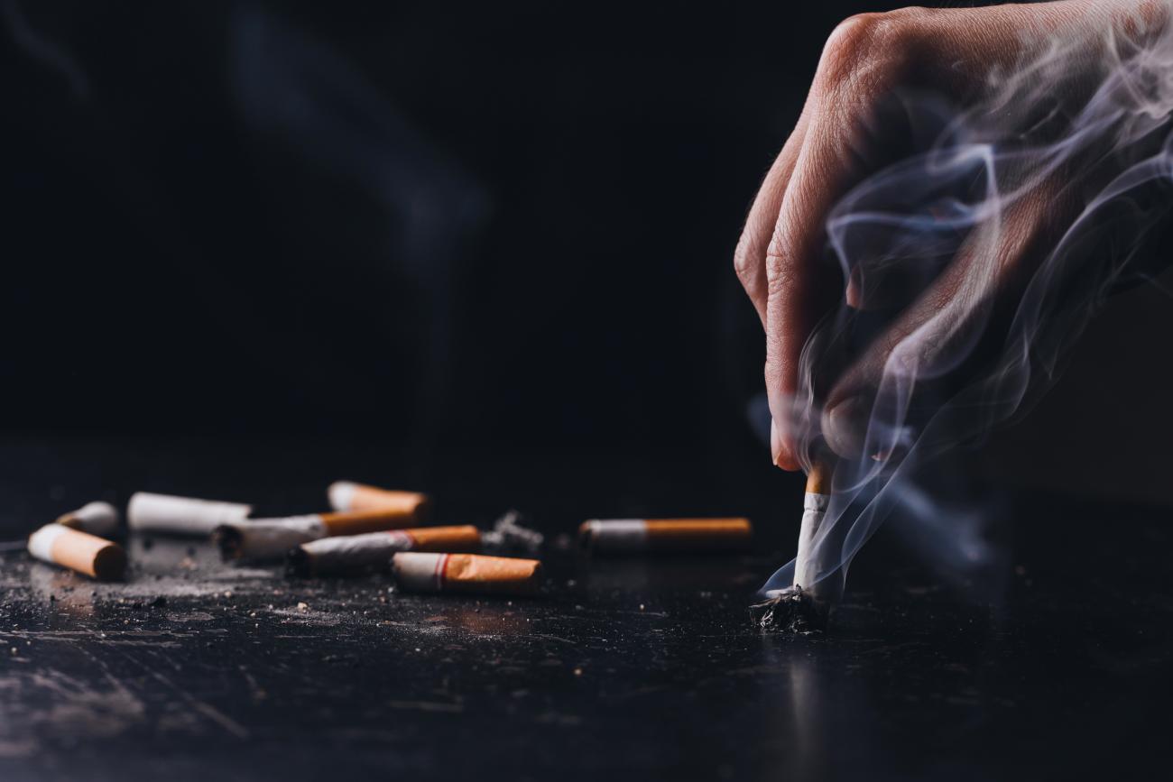 Photo of a hand putting out a cigarette.