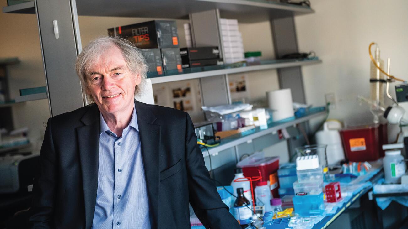 Dr. Peter Cullis smiling, in a lab. 