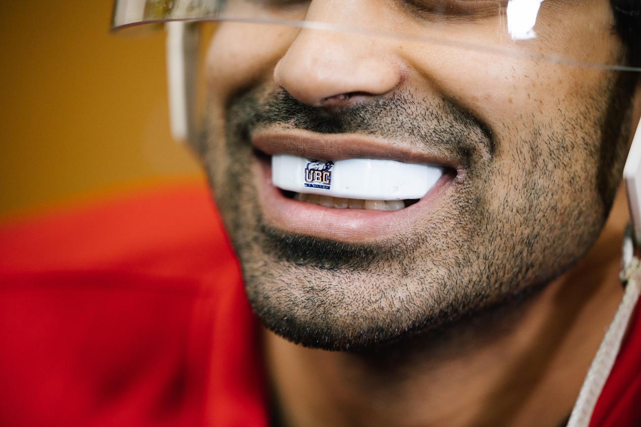 Close-up shot of a UBC hockey player wearing the high-tech mouthguard showing UBC Thunderbirds logo