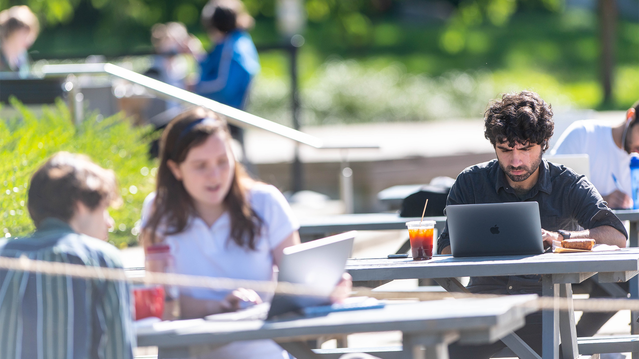 Photo of UBC students sitting at outdoor tables.