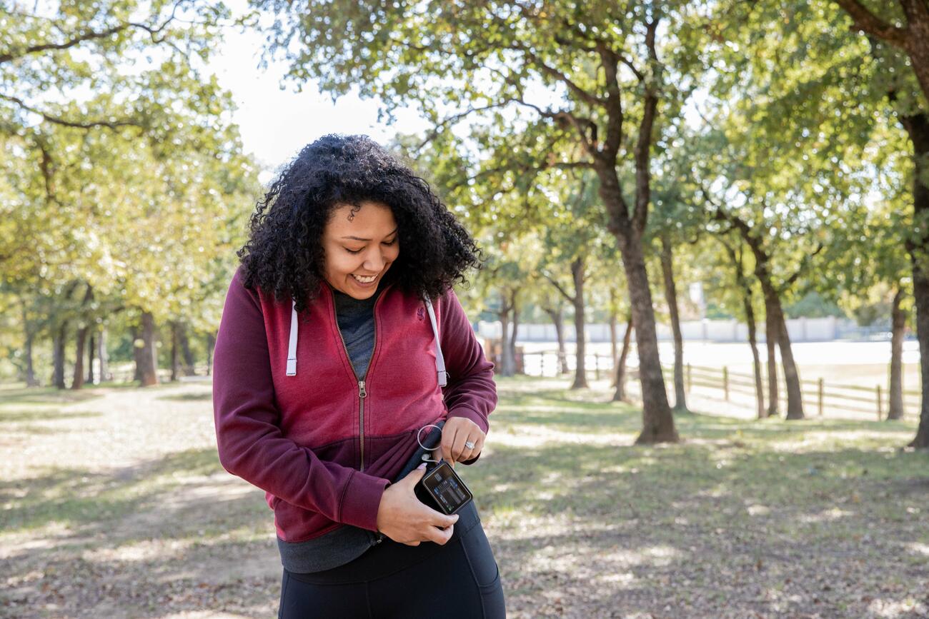 Women in exercise clothes checking a device while out walking