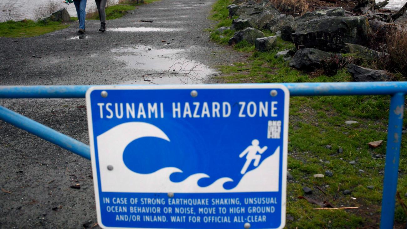 Blue sign on gate states "Tsunami hazard zone"