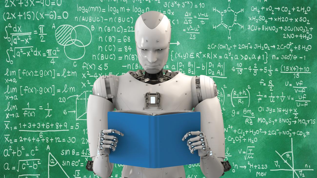 Robot reading book in front of chalkboard