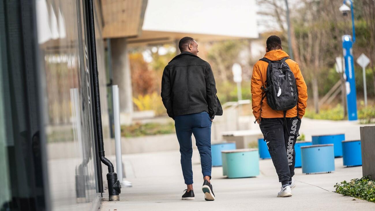 Two people walking together on UBC campus