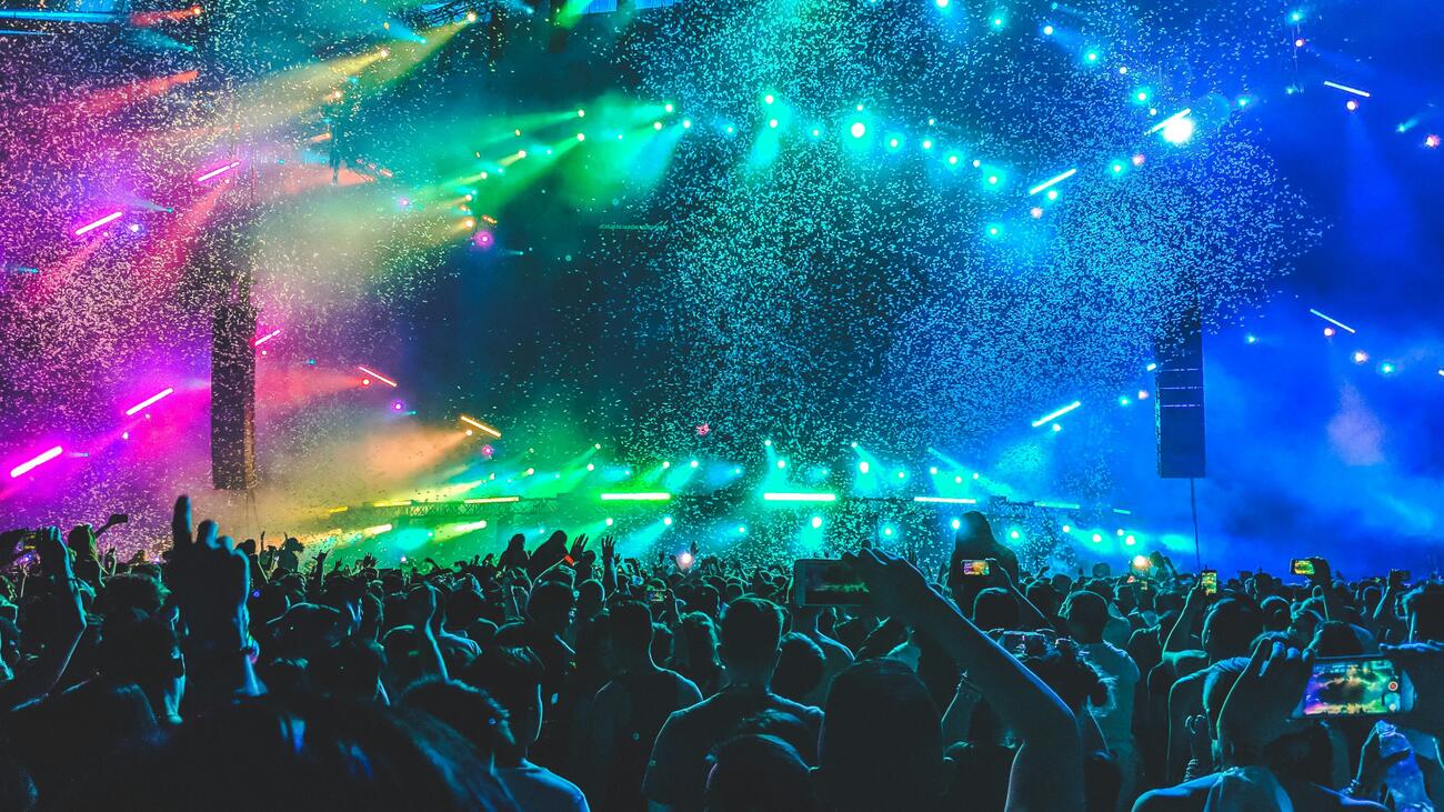 Audience facing stage amid confetti and lights at concert