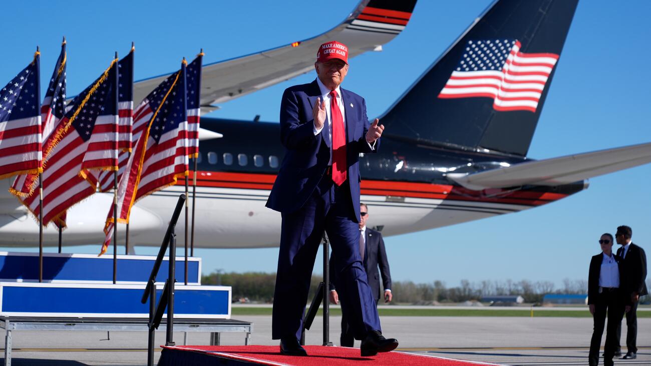 Donald Trump in front of U.S. flags and airplane 