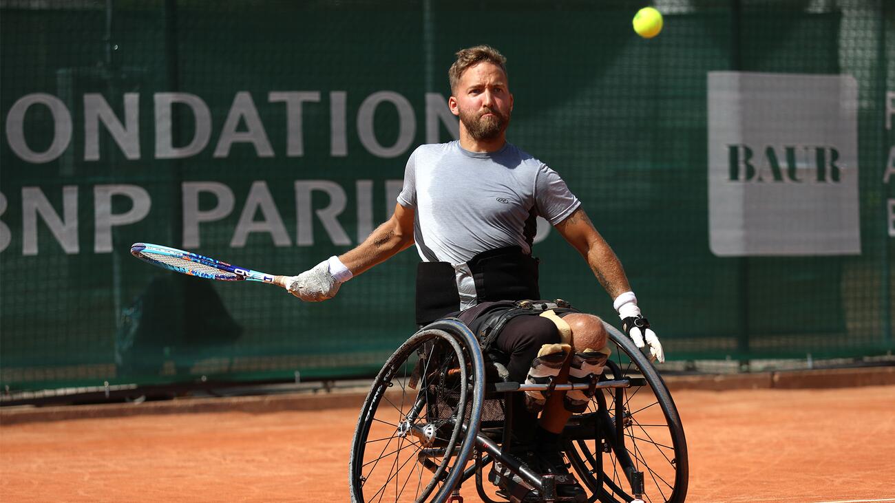 Rob Shaw playing tennis on a clay court