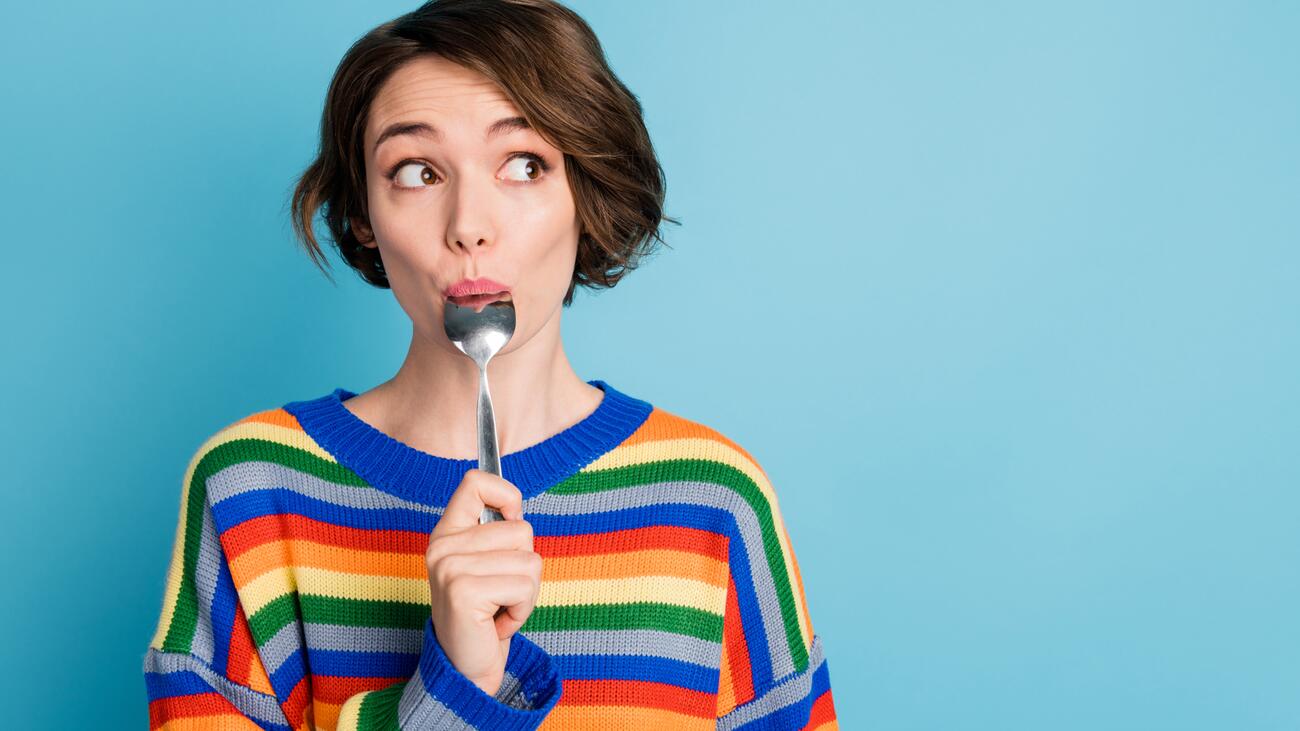 Student holding a spoon in her mouth with a surprised expression