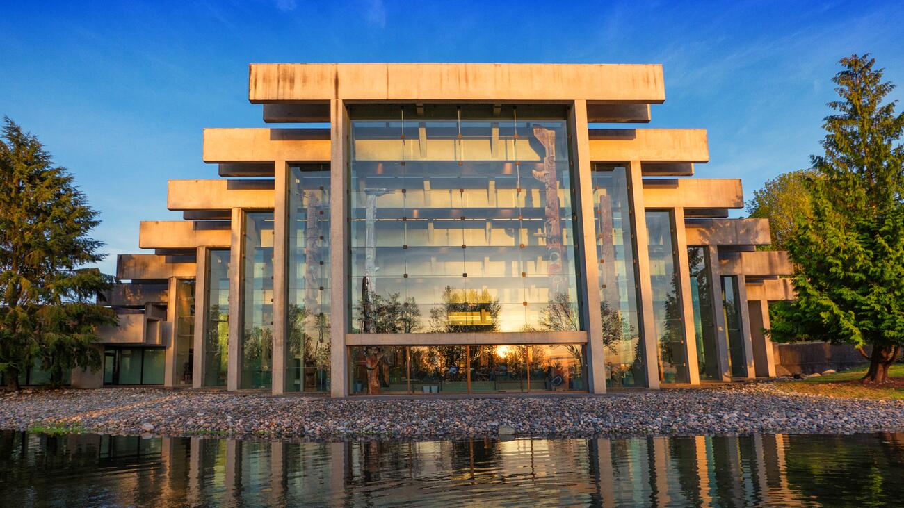 The Museum of Anthropology's concrete and glass facade looking glorious in the golden hour and reflecting in the reflecting pond 