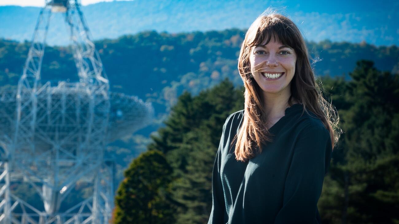 Smiling woman in front of outdoor radio telescope