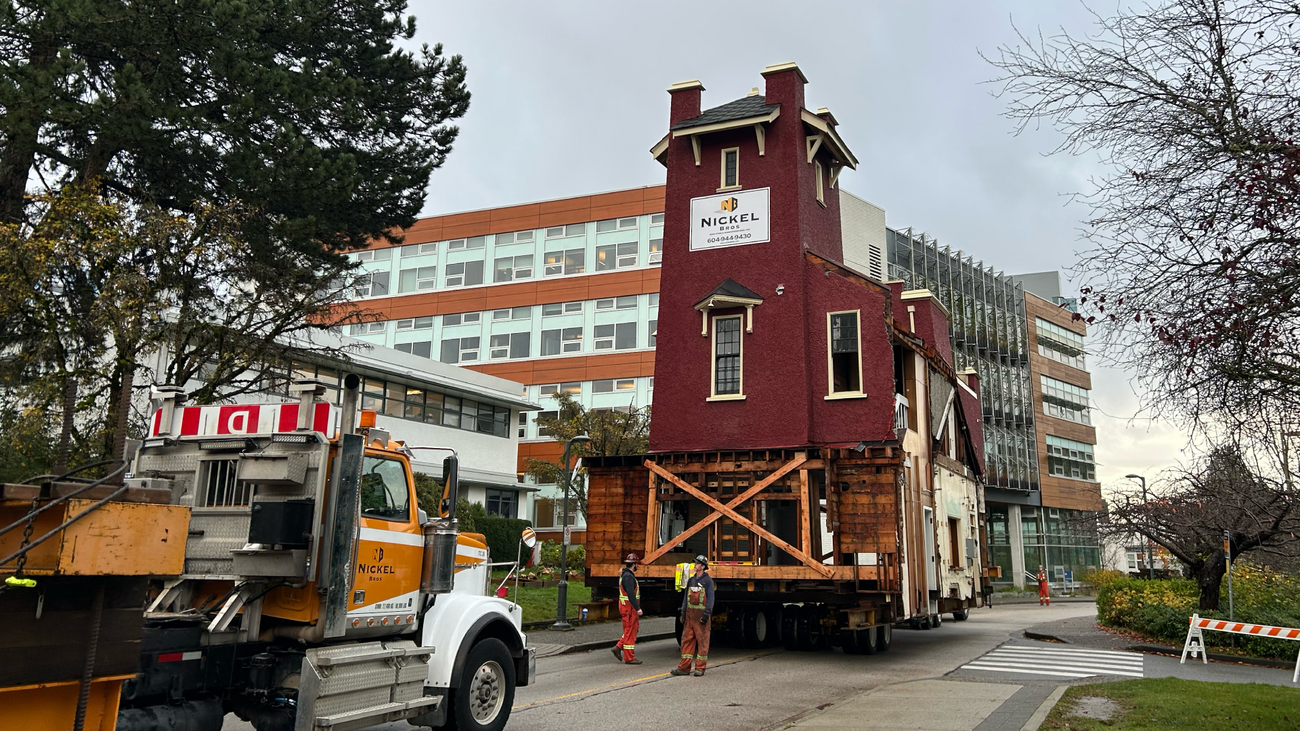 Traditional fire hall being carried on top of flatbed truck