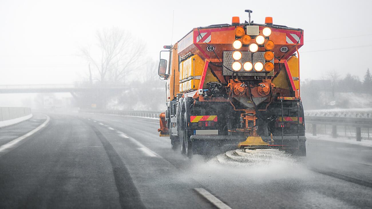 Truck spraying salt onto road in fog 