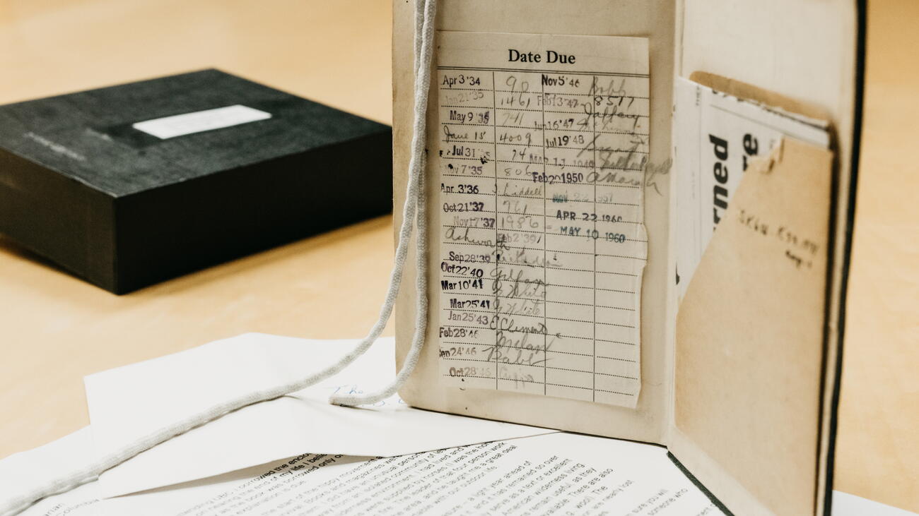 Open book with due date log beside box and papers