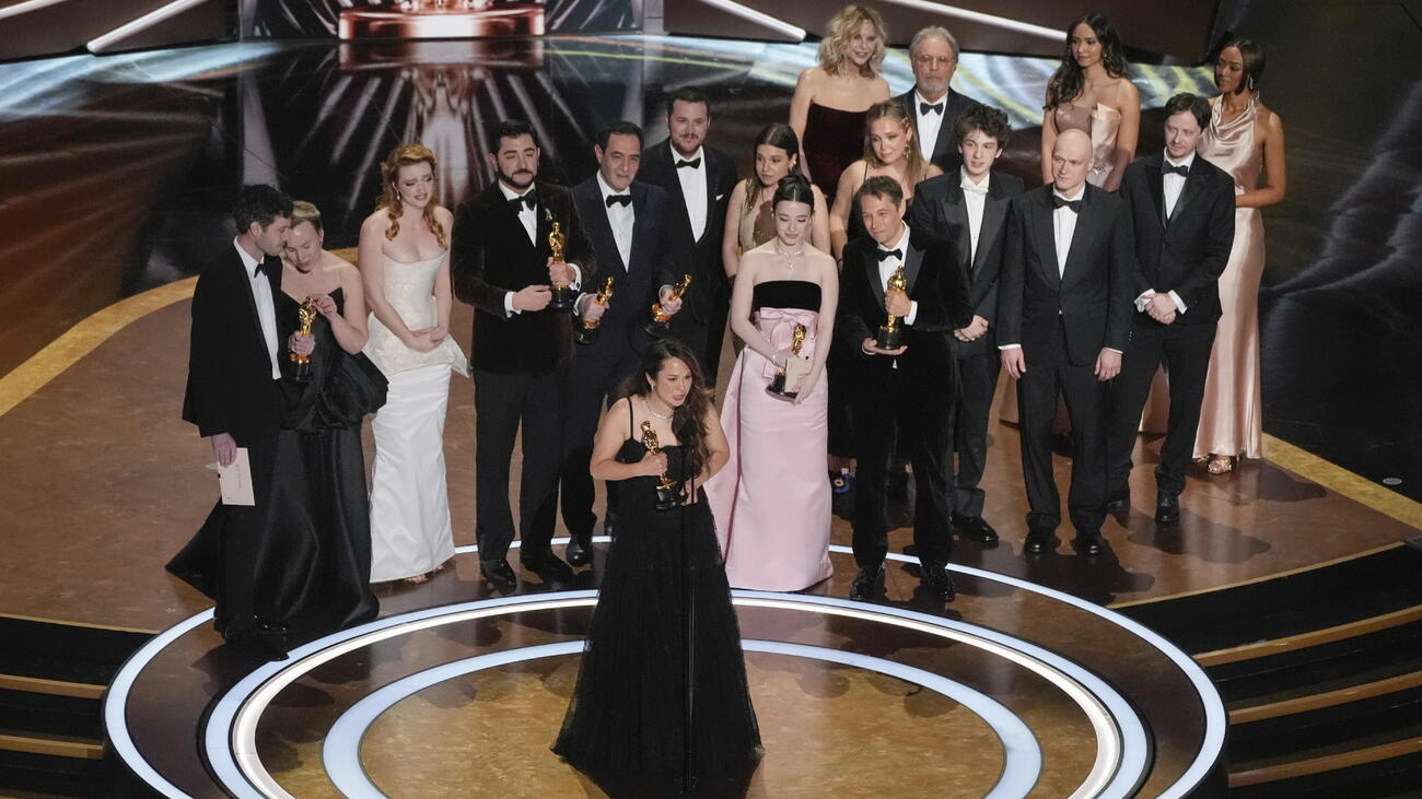 Samantha Quan giving her acceptance speech with the cast and team of her Oscar-winning film behind her