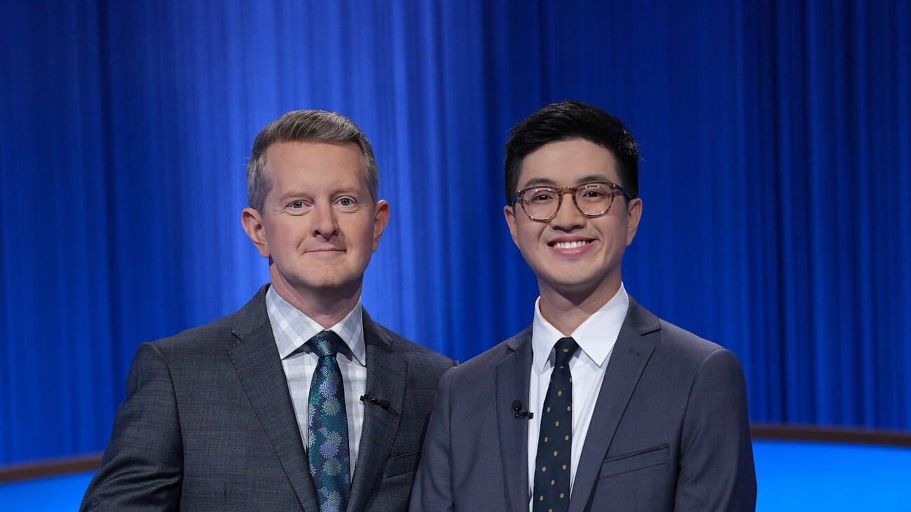 Jeopardy host stands beside winner on set