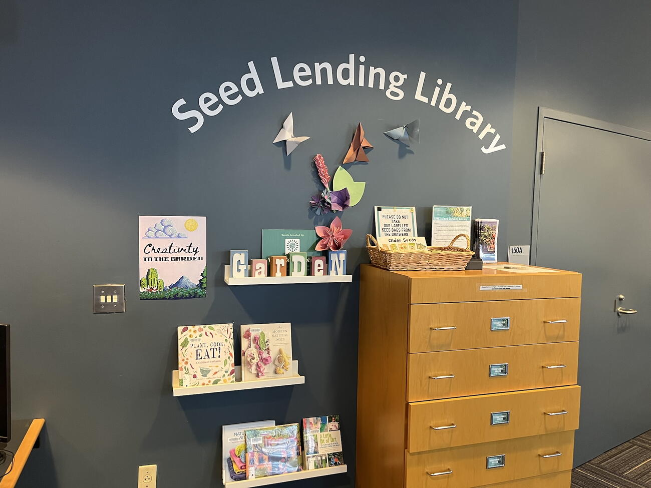 Shelves and dresser below "Seed Lending Library" sign