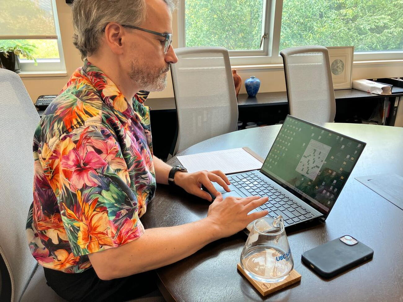 Man sits at table typing on laptop