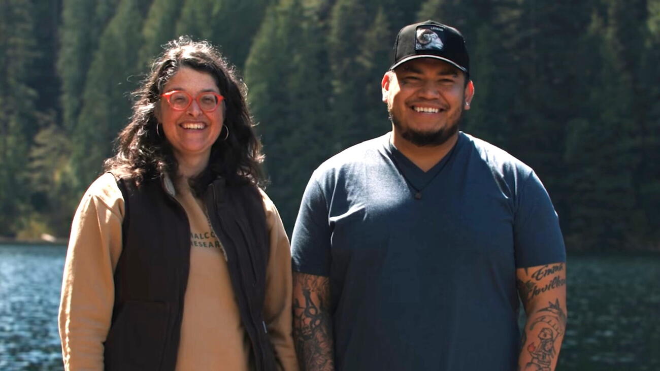 Photo of Hélène Marcoux (left) and Rain Pierre (sɬə́məx) (right) with a forest and river showing in the background.