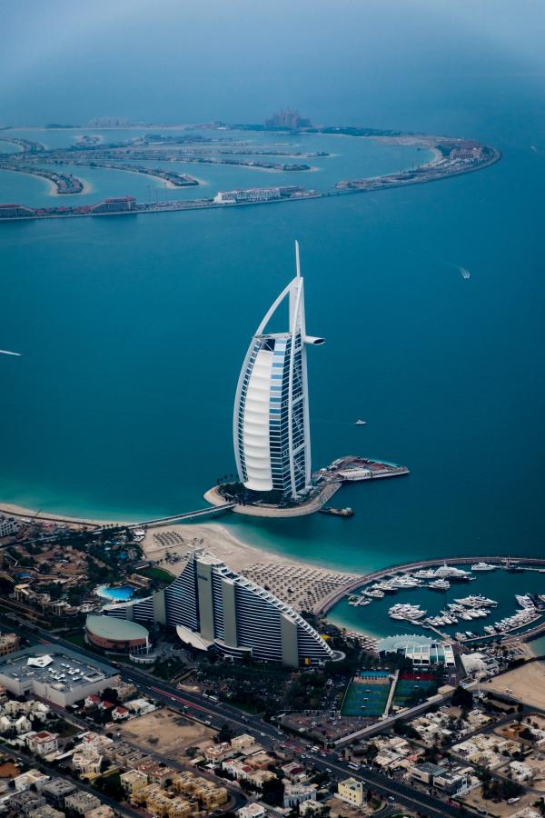 High-up view of the blue waters of the Persian Gulf with the Burj Al Arab Hotel in the centre
