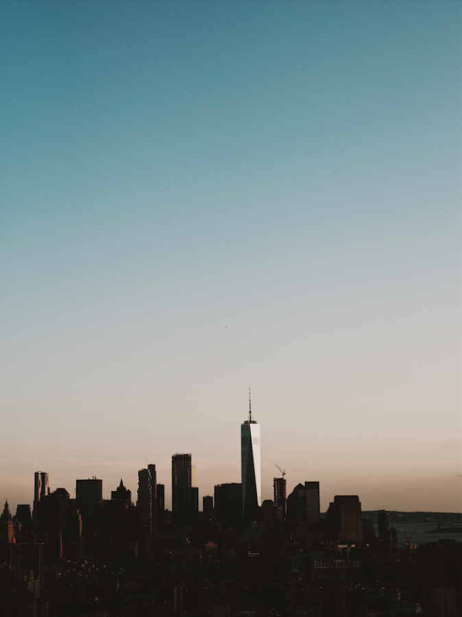 Silhouette of the New York City skyline at dusk, with a lot of sky showing