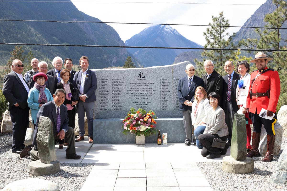Group of people stand beside rock monument at East Lillooet Memorial Garden