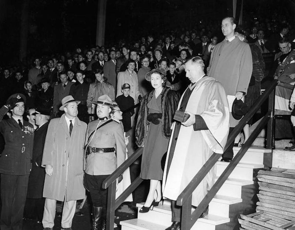 Princess Elizabeth and the Duke of Edinburgh are escorted down steps at UBC's Thunderbird Stadium