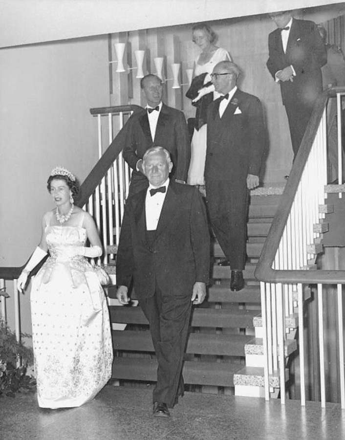 Queen Elizabeth and Norman MacKenzie descend staircase at UBC Faculty Club
