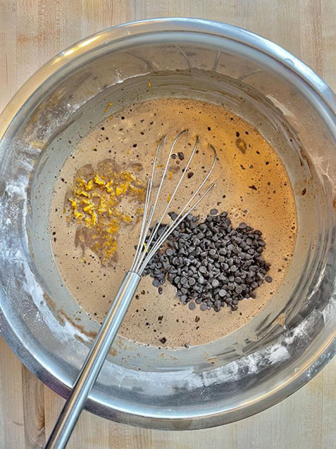 Bird's eye view of mixing bowl with baking ingredients and whisk
