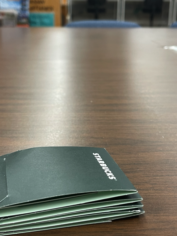 Stack of Starbucks gift cards lying in green gift card envelopes