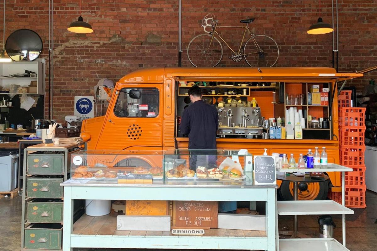 Coffee shop that features an orange van from where coffee is ordered and served
