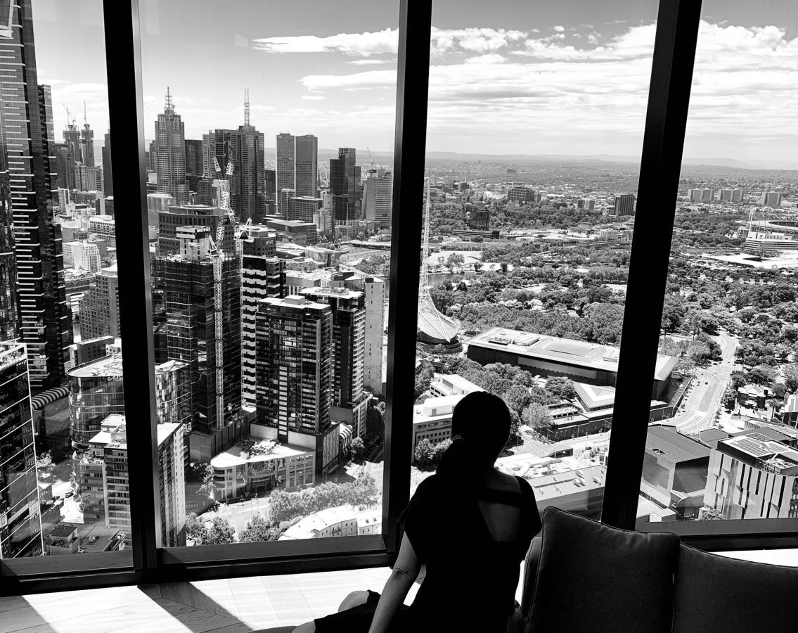 Wide-angle black-and-white shot of buildings and skyscrapers from a window in a hotel room high up