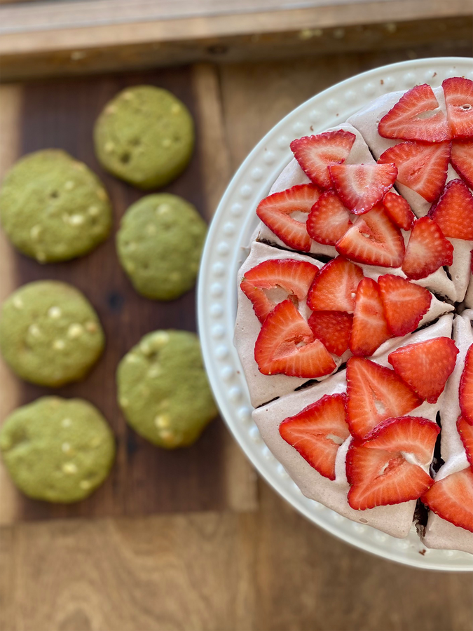 Overhead shot of matcha cookies on the left and a strawberry pie on the right