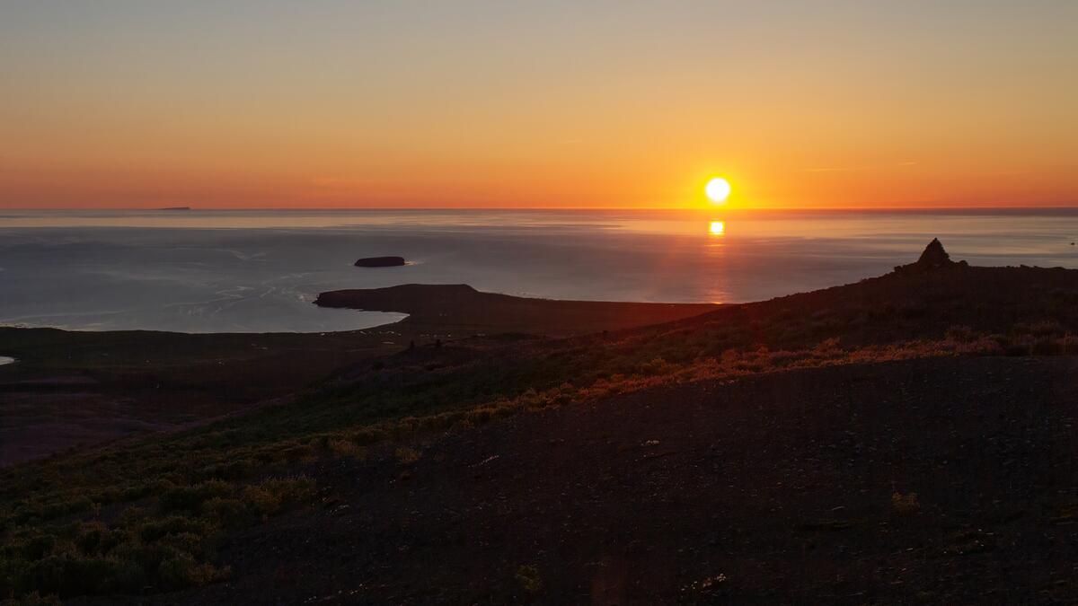 The midnight sun over Skjálfandi Bay from the top of Húsavík Mountain