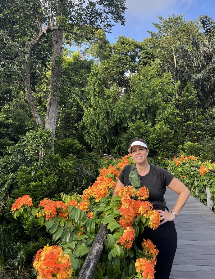 Suzanne posed among bright orange flowers at the Singapore Botanic Gardens