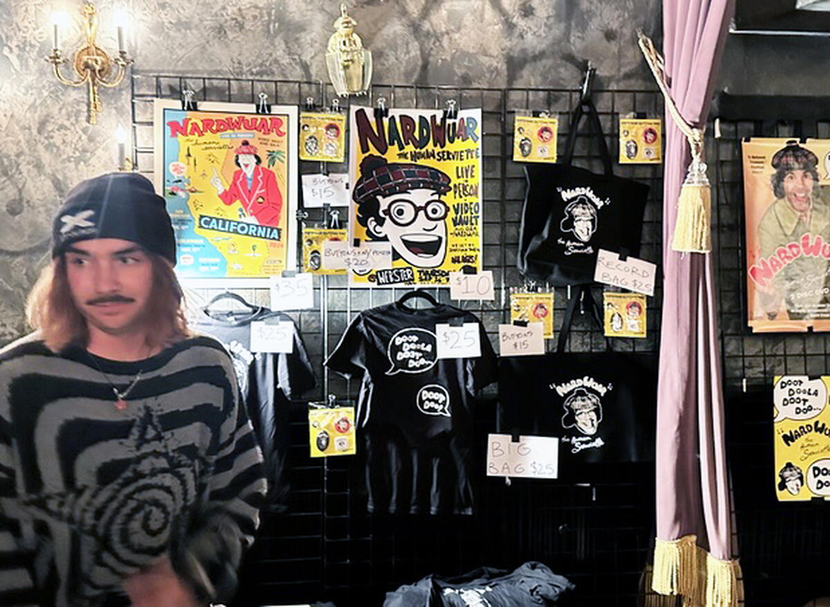 A wall displaying posters and paraphernalia about Nardwuar