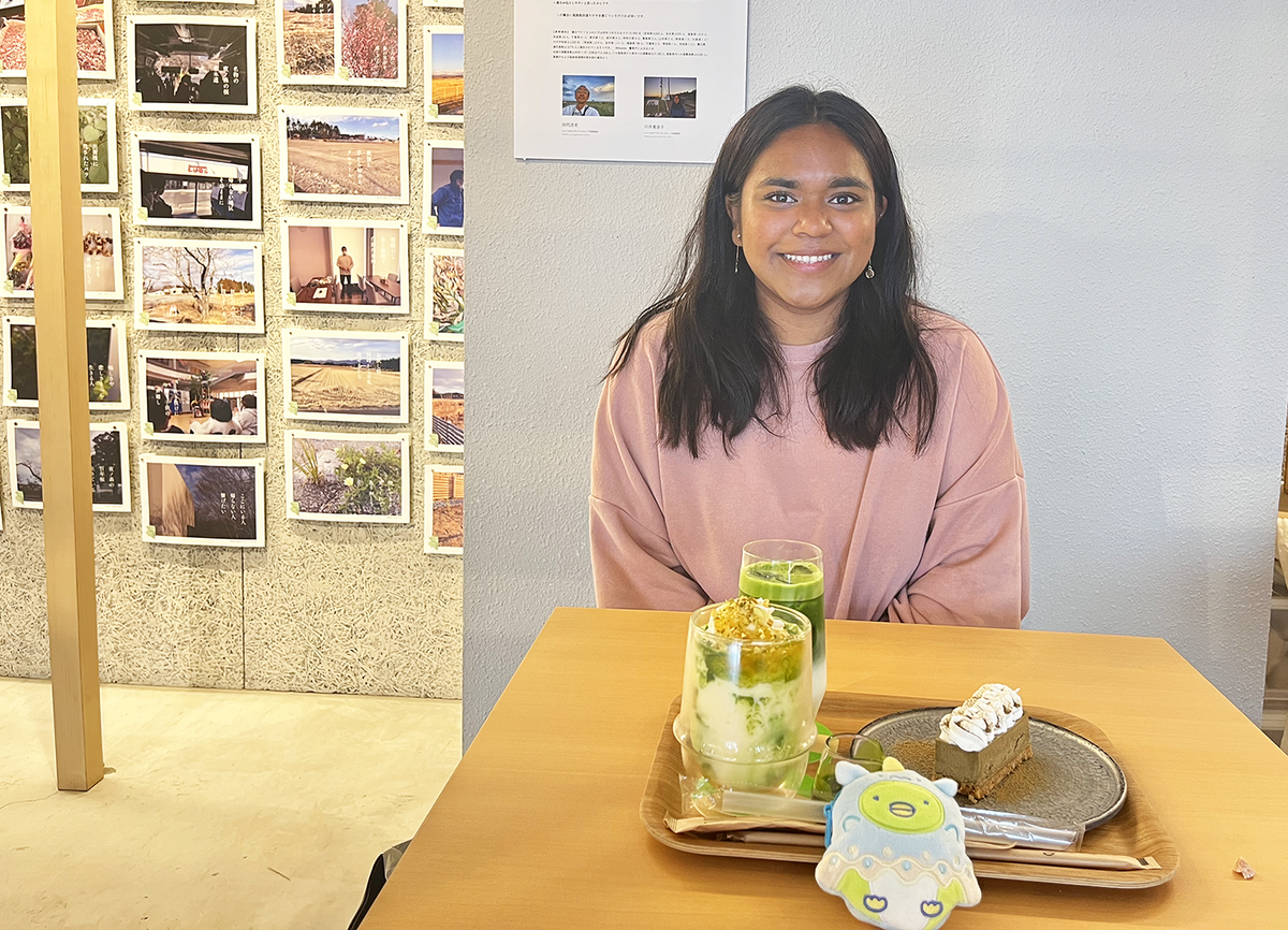 Hannah seated at a table with some drinks and sweets on it