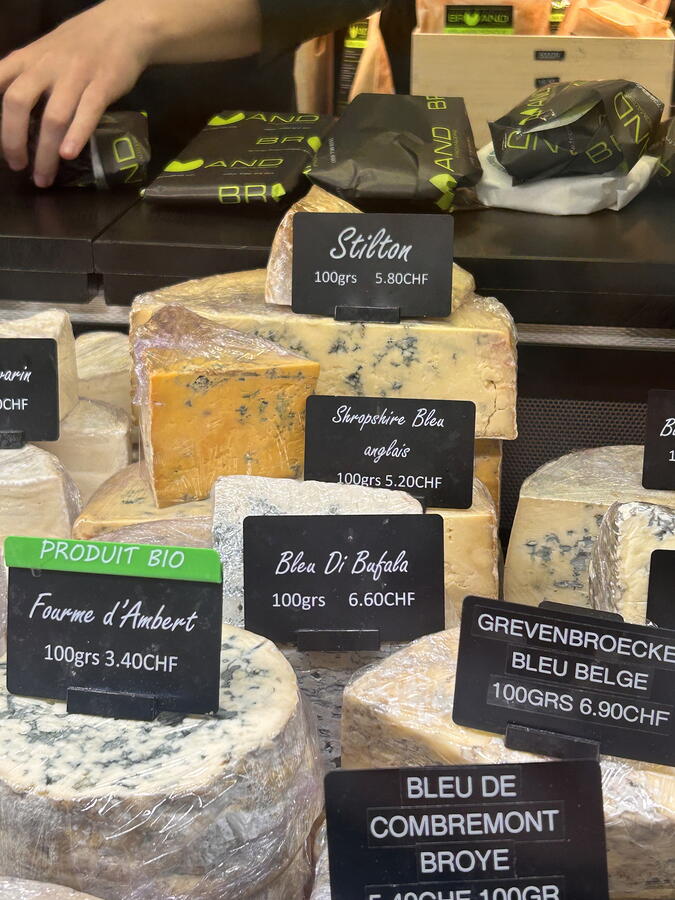 A close-up shot of a selection of cheeses in a shop