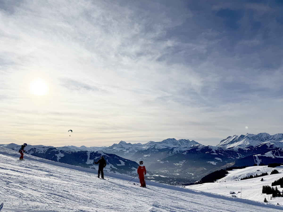Snowboarders in Megève, France, with mountains in the background