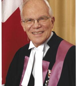 A photo of William Day in a suit with white and purple ribbons and a medal pinned to his chest.