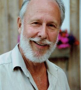 A headshot of Peter C. Clegg with white hair and a white beard, wearing a collared shirt.