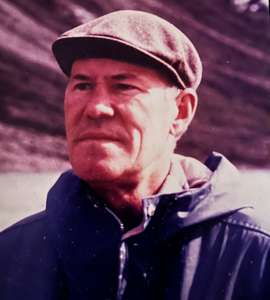 A photo of George Alden Worden wearing a pageboy cap and blue jacket.