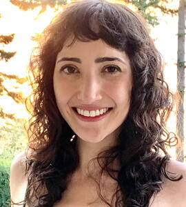 A portrait of Léa Taranto wearing a green floral dress in front of a garden.