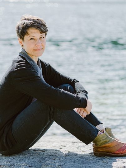 Photo of Sonja Thoma sitting on the beach.