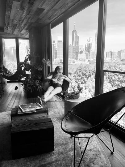 Black and white photo of a hotel room in NYC, with a view of the skyline in the background
