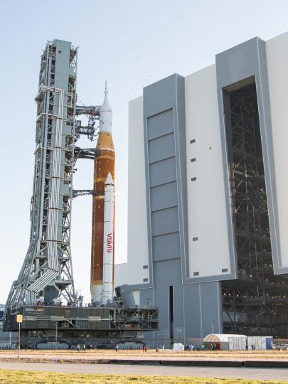 NASA rocket with spacecraft at launch complex on sunny day with clear skies