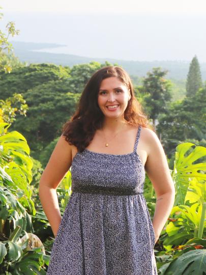 Alivia Prattas surrounded by greenery, with a view of Kona's south coast behind her