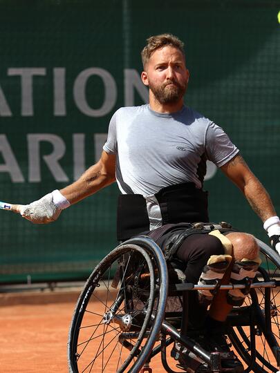 Rob Shaw playing tennis on a clay court