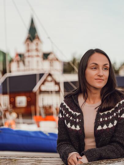 Charla Basran at Húsavík Harbor with a church in the background