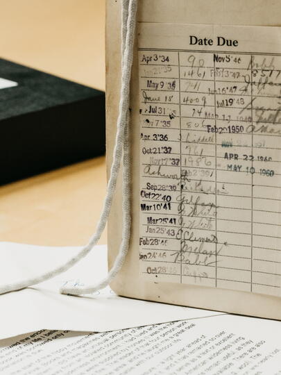 Open book with due date log beside box and papers