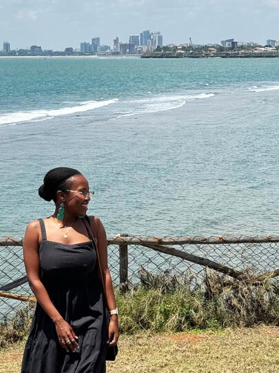 Portrait of Pieta outdoors with water and cityscape behind her